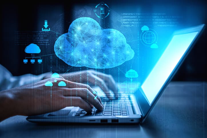 Person typing on a laptop with a glowing cloud computing graphic overlay, illustrating digital cloud technology