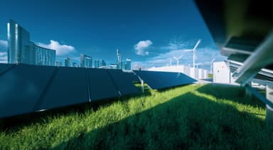 Solar panels, wind turbines, and battery storage units near a city skyline, illustrating sustainable energy infrastructure